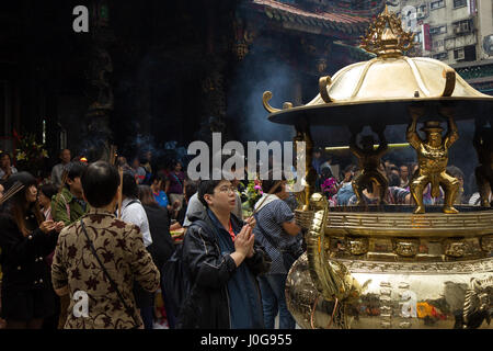 Eine Menge Leute mit Weihrauch beten klebt an der Mengjia Longshan Tempel in Taipei, Taiwan. Stockfoto