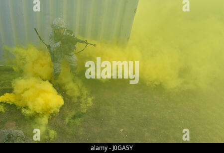 Ein Student der 435th Sicherheit Kräfte Squadron Ground Combat Readiness Training Center Security Operations Course ist umgeben von Rauch während der städtischen Operationen Teil des Kurses am U.S. Army Garrison Baumholder, Deutschland, 4. April 2017. Die Studierenden auch durchgeführt montiert und demontiert Operations während bei Baumholder. Flieger, die 86. SFS, 422. SFS 100. SFS und 569th US Kräfte Polizei Geschwader zugewiesen beteiligte sich an den Kurs. (Foto: Senior Airman Tryphena Mayhugh US Air Force) Stockfoto