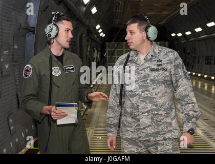 Chief Master Sgt. Steve Nichols, 60 Air Mobility Wing Befehl Chef und Flieger 1. Klasse Aaron Walker, 22. Airlift Squadron, zusammengetan, um Loadmaster Aufgaben an Travis Air Force Base, Kalifornien, 7. April 2017 als Teil der Werke mit Flieger-Programm. Walker ging Nichols durch den Prozess der eine Belastung eine hohe Mobilität Mehrzweck Rädern Fahrzeug (HMMWV) in eine C5-M Super Galaxy-Flugzeug. Die Werke mit Flieger-Programm soll Flügel Führung ermöglichen die Möglichkeit, Schatten junior eingetragenen Flieger und erhalten aus erster Hand Erfahrungen wie der Flieger Pflichten und Verantwortlichkeiten schwie- Stockfoto