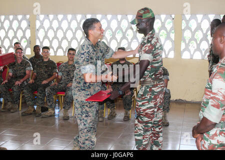 Pvt. Angel Gonzales, ein Schütze mit speziellen Zweck Marine Air-Ground Task Force – Crisis Response – Afrika, präsentiert eine Bescheinigung über den Abschluss einem Soldaten mit der kamerunischen Commando-Schifffahrtsgesellschaft während einer Abschlussfeier am Isongo Trainingsbereich, Limbe, Kamerun, 10. März 2017. Diese Marines dienen als das Grundkampfelement für SPMAGTF-CR-AF, ermöglichen den Schutz von US-Soldaten, Eigentum und Interessen in Europa und Afrika. (Foto: U.S. Marine Corps CPL Robert Piedra/freigegeben) Stockfoto