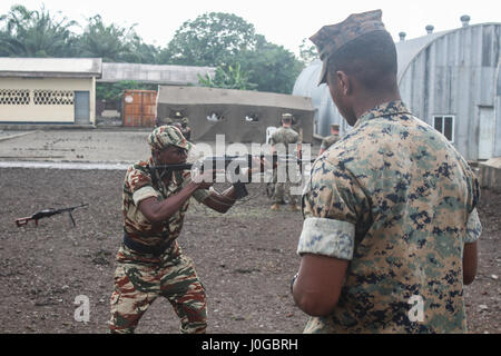 Lance Cpl. Christian Hall, ein Schütze mit speziellen Zweck Marine Air-Ground Task Force – Crisis Response – Afrika, weist ein Soldat mit der kamerunischen Commando-Schifffahrtsgesellschaft auf richtigen Dreharbeiten Positionen bei Isongo Trainingsbereich, Limbe, Kamerun, 13. Februar 2017. Diese Marines dienen als das Grundkampfelement für SPMAGTF-CR-AF, ermöglichen den Schutz von US-Soldaten, Eigentum und Interessen in Europa und Afrika. (Foto: U.S. Marine Corps CPL Robert Piedra/freigegeben) Stockfoto