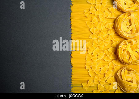 Ansicht von oben: Pasta oder italienische Spaghetti auf schwarzem Stein Schiefer Hintergrund. Textfreiraum Stockfoto