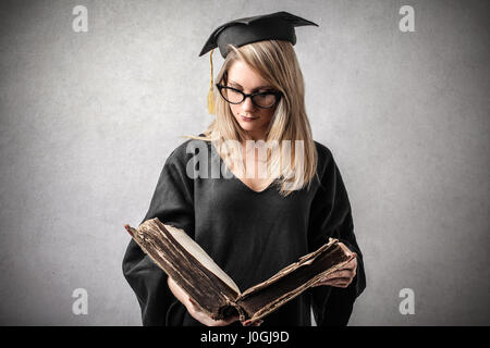 Blonde Frau, die mit alten Buch Abschluss Stockfoto