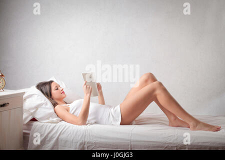 Frau im Bett lesen Stockfoto