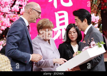 Hannover, Deutschland. 20. März 2017. Timotheus Höttges (links), Vorstandsvorsitzender Deutsche Telekom AG, trifft Angela Merkel, Kanzler der Bundesrepublik Deutschland und Shinzo Abe, Premierminister von Japan, am Messestand der Telekom, CeBIT-Spaziergang, CeBIT 2017, IKT-Handel fair, Lead Anfangsthema würde! Conomy - keine grenzenlos. Photocredit: Christian Lademann Stockfoto