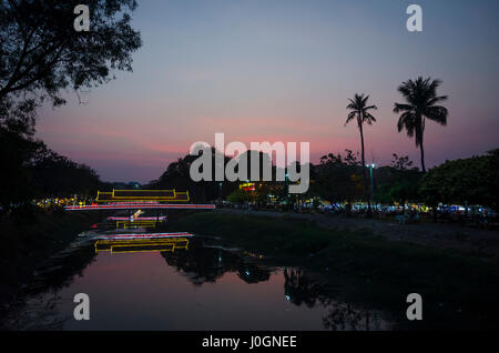 Beleuchtete gedeckte Brücke über Fluss bei Sonnenuntergang, Siem Reap, Kambodscha. Stockfoto