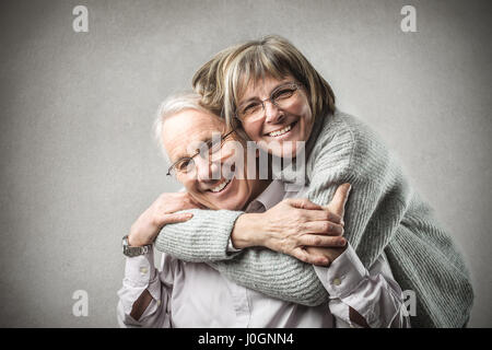 Altes Paar umarmten einander und lächelnd Stockfoto