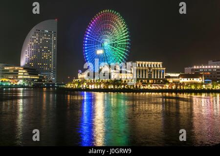 Beleuchtete Nachtaufnahme des Bereichs Shinko in Minato Mirai 21 Bezirk von Yokohama, Japan, einschließlich der Cosmo World Vergnügungspark Stockfoto