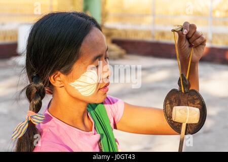 Myanmar-Frau mit Thanaka im Gesicht Smiley Mandalay, Myanmar. Thanaka ist eine gelblich-weiße kosmetische Paste aus Boden Rinde hergestellt. Stockfoto