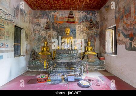 Sitzende Buddha-Statue mit Wandmalereien im Hintergrund, Wat Pak Huak, Luang Prabang, Laos, Indochina, Südostasien, Asien Stockfoto