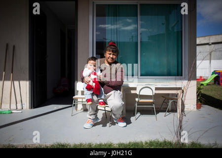 (170413)--FLORENCIO VARELA, 13. April 2017 (Xinhua)--Miriam Sotelo Sosa (R) und ihren acht Monate alten Sohn Ciro Pose vor dem Haus, die sie mit drei Frauen Häftlinge und ihre Kinder in der Verbrecher-Einheit 54 im Rahmen des Pilotprogramms "Häuser für Frauen mit Kindern" in Argentinien, Florencio Varela Stadt am 12. April 2017. Das pilot-Programm ins Leben gerufen durch das Justizministerium in der Provinz Buenos Aires soll die Lebensqualität der Frauen Häftlinge zu verbessern, die mit ihren Kindern leben. Das Programm Offerd kleinen Häusern in einem Gefängnis Komplex, so dass die Kinder die AEMT vermeiden kann Stockfoto