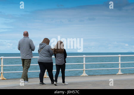 Aberystwyth Wales UK, Donnerstag, 13. April 2017 UK Wetter: eine Familie gekleidet in passenden grauen Oberteile zu Fuß direkt an der Strandpromenade an einem kalten aber hellen und luftigen Tag in Aberystwyth, Wales, am Vorabend von Ostern Bank Holiday Wochenende Foto Credit: Keith Morris/Alamy Live News Stockfoto