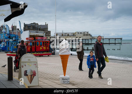 Aberystwyth Wales UK, Donnerstag, 13. April 2017 UK Wetter: Menschen zu Fuß auf der Strandpromenade promenade an einem kalten aber hellen und luftigen Tag in Aberystwyth, Wales, am Vorabend von Ostern Bank Holiday Wochenende Foto Credit: Keith Morris/Alamy Live News Stockfoto