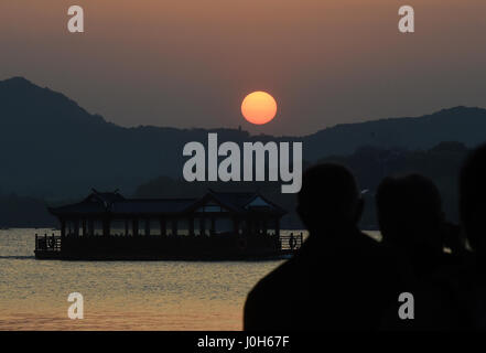 Hangzhou, China Zhejiang Provinz. 13. April 2017. Menschen beobachten Sonnenuntergang am Westsee in Hangzhou, Hauptstadt der ostchinesischen Provinz Zhejiang, 13. April 2017. Bildnachweis: Han Chuanhao/Xinhua/Alamy Live-Nachrichten Stockfoto