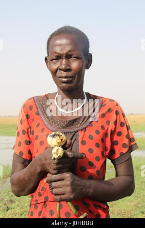 Nyal, Süd-Sudan. 27. März 2017. Magai Mayak Gatbuok hält die Knospen der essbaren Seerosen, die sie in den Sümpfen des Weißen Nil River nahe Nyal, Süd-Sudan, 27. März 2017 gefunden. Es befindet sich im sudanesischen Bundesstaat Unity, der Region von Hungersnot im Land am stärksten betroffen. Sie braucht etwa 50 der Knospen, eine ganze Mahlzeit für ihre Familie vorzubereiten. Foto: Jürgen Bätz/Dpa/Alamy Live News Stockfoto