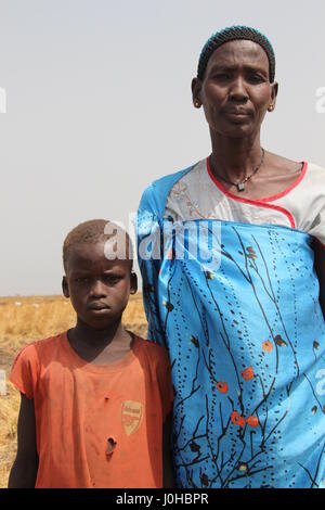 Ganyliel, Süd-Sudan. 24. März 2017. Mary Nyak Badoy (R), Mutter von zehn Kindern, zusammen mit einem ihrer Söhne, erwartet die monatliche Verteilung der Hilfsgüter in Ganyliel, Süd-Sudan, 24. März 2017. Es befindet sich im sudanesischen Bundesstaat Unity, der Region von Hungersnot im Land am stärksten betroffen. Foto: Jürgen Bätz/Dpa/Alamy Live News Stockfoto