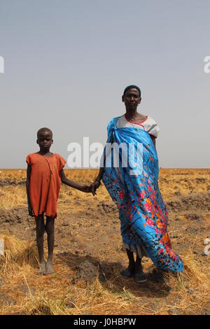 Ganyliel, Süd-Sudan. 24. März 2017. Mary Nyak Badoy (R), Mutter von zehn Kindern, zusammen mit einem ihrer Söhne, erwartet die monatliche Verteilung der Hilfsgüter in Ganyliel, Süd-Sudan, 24. März 2017. Es befindet sich im sudanesischen Bundesstaat Unity, der Region von Hungersnot im Land am stärksten betroffen. Foto: Jürgen Bätz/Dpa/Alamy Live News Stockfoto