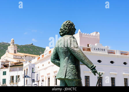 Cadaques Stadt, Fokus auf Salvador Dalí Statue mit dem alten Casino-Gebäude und Kirche von Santa Maria im Hintergrund, Cadaques, Katalonien, Spanien Stockfoto