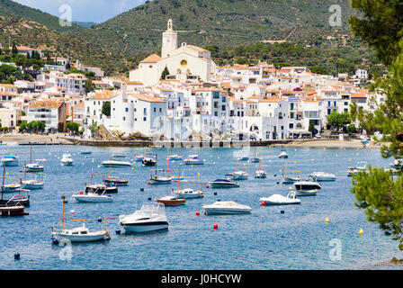 Weiß getünchten Dorf Cadaqués gekrönt von der Kirche Santa Maria mit Blick auf Boote in den blauen Gewässern des Cadaques Bucht, Cadaques, Katalonien, Spanien Stockfoto