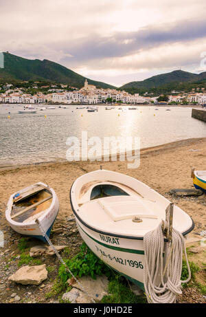 Späten Nachmittag Sonne über den weiß getünchten Dorf Cadaqués, gekrönt von der Kirche Santa Maria mit Blick auf Boote in Cadaques Bucht, Katalonien, Spanien Stockfoto