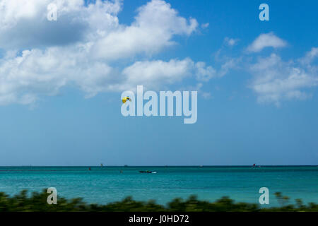 Parasailing über das türkisblaue Wasser der Karibik vor der Küste von Aruba. Stockfoto