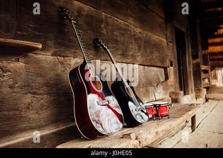 Gitarre, stützte sich auf eine alte hölzerne Veranda Stockfoto