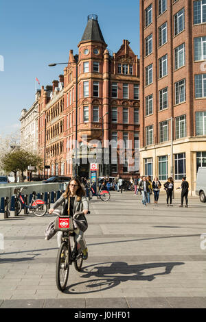 Studenten und eine Frau, die auf einem Boris Bike vor der University of Notre Dame, Waterloo, London, SE1, England, UK Stockfoto