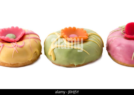 Drei Ostern Donuts mit einer Marzipan-Blume an der Spitze. Stockfoto