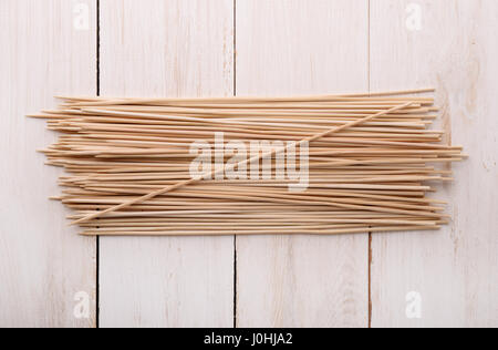 Draufsicht auf Holzspieße auf weißen Holzoberfläche Stockfoto
