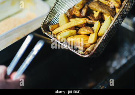 Teil von Hand geschnitten Kartoffel-Chips in einer Pfanne erhitzen Stockfoto