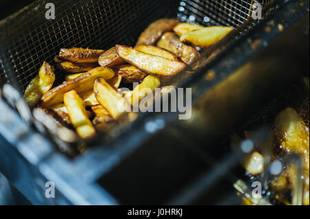 Teil von Hand geschnitten Kartoffel-Chips in einer Pfanne erhitzen Stockfoto