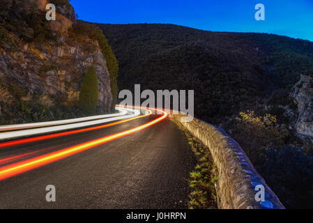 Leuchtspuren von eine Belichtungszeit von Autolichter in der Nacht, eine Kurve auf einer Bergstraße Rundung. Stockfoto