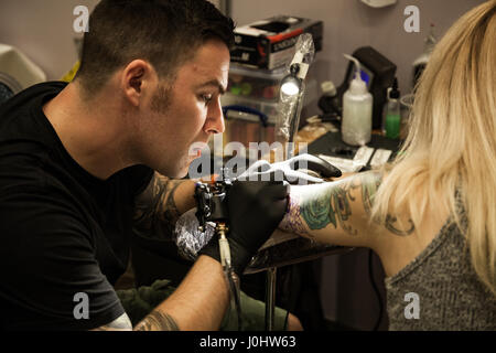 GALWAY, Irland - SEPTEMBER 12: Tattoo-Künstler bei der Arbeit während der 3. jährlichen internationalen Galway Tattoo Show am 12. September 2015 Stockfoto