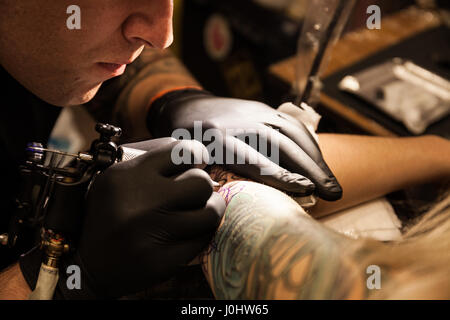 GALWAY, Irland - SEPTEMBER 12: Tattoo-Künstler bei der Arbeit während der 3. jährlichen internationalen Galway Tattoo Show am 12. September 2015 Stockfoto