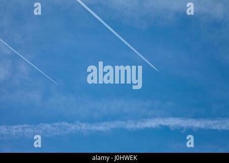 Flugzeuge fliegen in den blauen Himmel zwischen den Wolken und Sonne Stockfoto