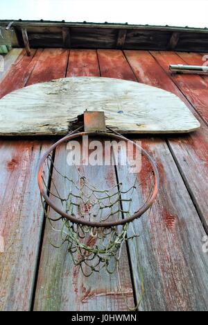 Alten Basketballkorb auf rote Scheune Wand Stockfoto