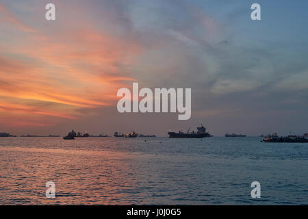 Sonnenaufgang über dem Cargo-Schiffe vor Anker In der Straße von Singapur. Stockfoto