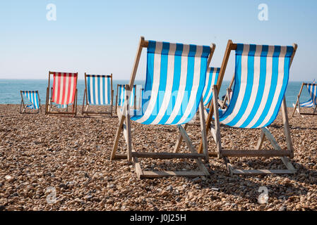 Leere traditionellen gestreiften Liegestühlen auf Brighton Beach, England, UK Stockfoto