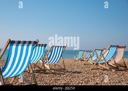 Leere traditionellen gestreiften Liegestühlen auf Brighton Beach, England, UK Stockfoto