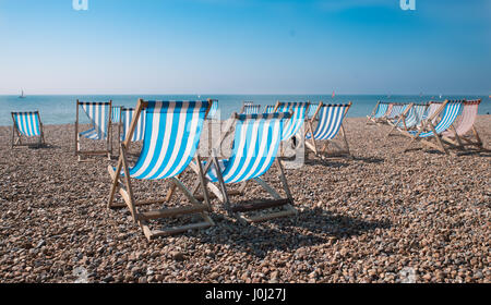 Leere traditionellen gestreiften Liegestühlen auf Brighton Beach, England, UK Stockfoto