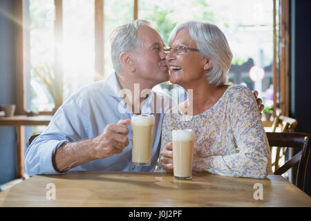 Ältere Mann küssen senior Frau in CafÃƒÂ © Stockfoto