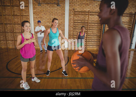 Entschlossene Mädchen hält einen Basketball im Hof Stockfoto