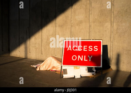 Ein Obdachloser schläft zwischen ein Zugang nur Schild und eine solide Betonwand - Liverpool Street, London April 2017 Stockfoto