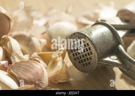 Nahaufnahme, Gruppe von Knoblauchzehen und Knoblauchpresse Stockfoto