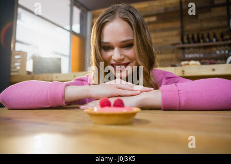 Schöne Frau betrachten Cupcake in CafÃƒÂ © Stockfoto