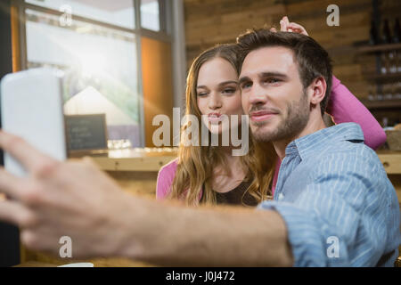 Junges Paar nehmen Selfie auf Handy in CafÃƒÂ © Stockfoto