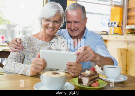 Gerne älteres Paar mit digital-Tablette in CafÃƒÂ © Stockfoto