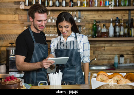 Kellner und Kellnerinnen mit digital-Tablette am Schalter im CafÃƒÂ © Stockfoto