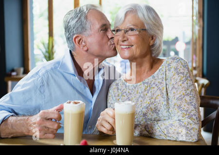 Ältere Mann küssen senior Frau in CafÃƒÂ © Stockfoto