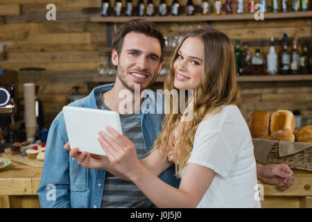 Porträt der lächelnde paar mit digital-Tablette am Schalter im café Stockfoto